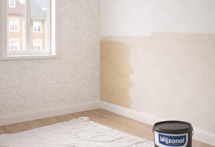 Kinderkamer die wordt geschilderd met beige verf, Wijzonol verfemmer en roller op de vloer